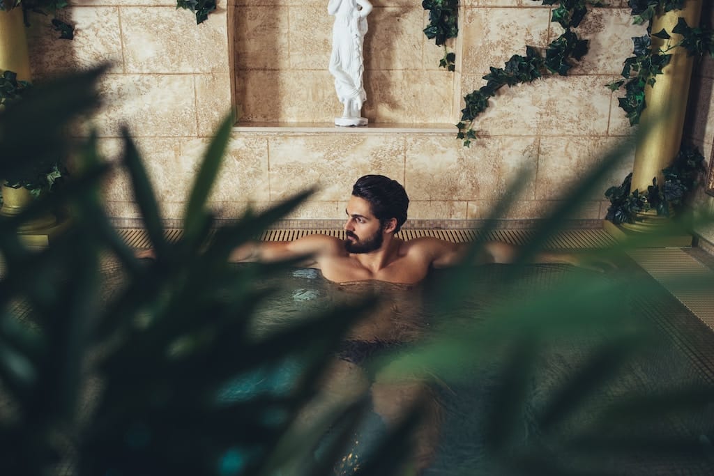 Man relaxing in a pool, enjoying a tranquil and refreshing moment.